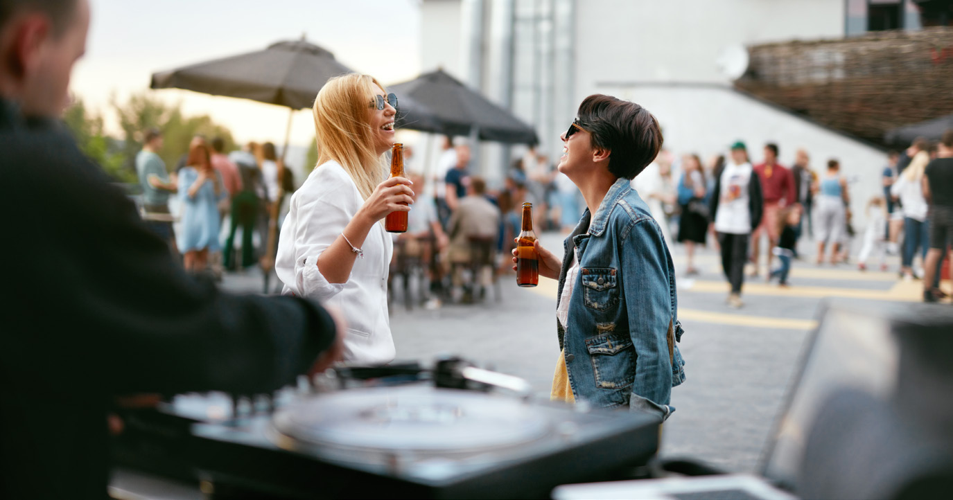 Besucherinnen mit Getränken bei einem Straßenfest
