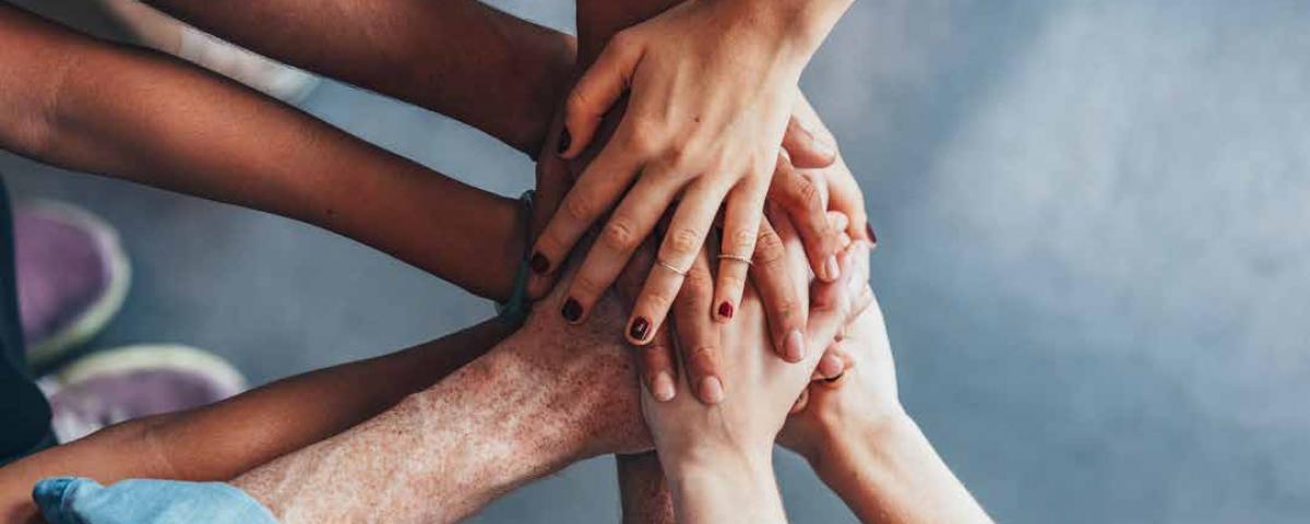Mehrere Personen legen ihre Hände übereinander und symbolisieren die interkommunale Zusammenarbeit im EGON-Wirtschaftsraum.