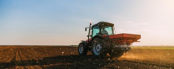Traktor bringt Dünger auf einem Feld aus